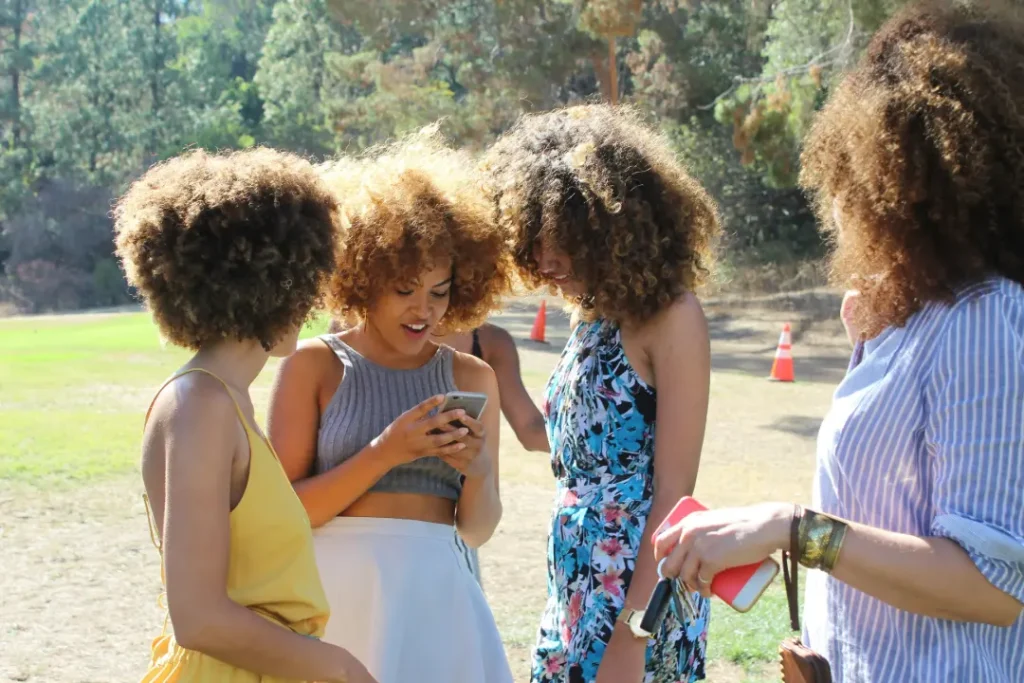 African American women in a park with cell phones
